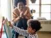 Happy black woman play and learning with little kid at home. Education children development concept
